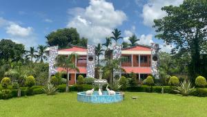 ein Haus mit einem Brunnen vor einem Hof in der Unterkunft Jungle Bell Resort in Lataguri