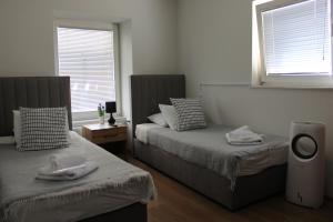 two beds in a room with two windows at Šeherezada Rooms in Ljubljana +12 photos