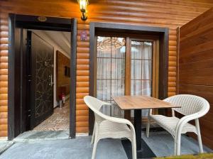 a wooden table and chairs on a patio with a door at Centro Park Hotel in Uzungöl