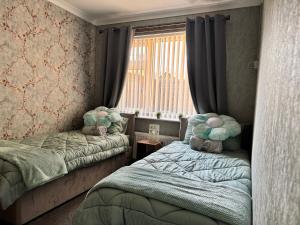 a bedroom with two twin beds and a window at Ash Cottage in Tollerton