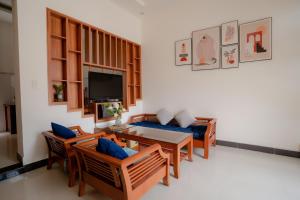 a living room with a table and chairs and a television at Nhà Chang Homestay in Dong Hoi