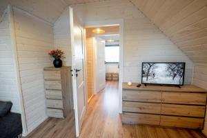 a tiny house with a staircase leading to the attic at Ross-domki LUX Hause & Jacuzzi in Sarbinowo +17 photos
