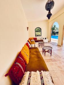 a living room with a couch with colorful pillows at Luxury Spot 2026 - Riad Sahara Experience - Piscine in Imalalene +72 photos