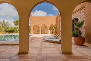 an arched entryway to a villa with a swimming pool at Luxury Spot 2026 - Riad Sahara Experience - Piscine in Imalalene