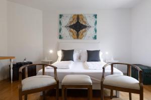 a bedroom with a bed with two chairs and a painting at Torbole Holiday House in Nago-Torbole