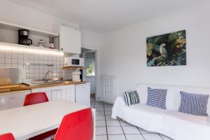 a kitchen and a living room with a table and a couch at Torbole Holiday House in Nago-Torbole