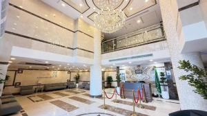 Un vestíbulo de un hotel con una lámpara de araña. en ملتزم الضيافة للشقق الفندقية, en La Meca