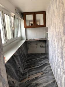 a kitchen with a marble floor and two windows at Kirayə ev in Mekhrably