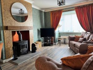 a living room with a couch and a fireplace at Ash Cottage in Tollerton