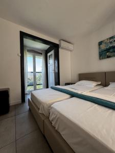 zwei Betten in einem Zimmer mit Fenster in der Unterkunft Belvedere Costinesti in Costinești