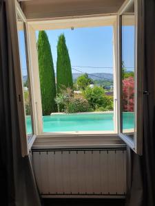 a window with a view of a swimming pool at La Villa St Roch in Malaucène