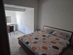 a bedroom with a bed and a table and a chair at Apartman Pecara in Široki Brijeg