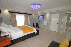 a bedroom with a large bed and a chandelier at Comfortable 4 Bedroom Flat in Germiston with WI-FI in Germiston