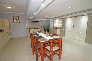 a kitchen with a table and chairs in it at Comfortable 4 Bedroom Flat in Germiston with WI-FI in Germiston