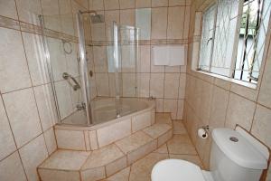 a bathroom with a shower and a tub and a toilet at Comfortable 4 Bedroom Flat in Germiston with WI-FI in Germiston +55 photos