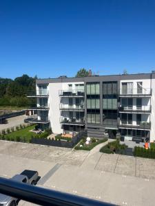 a large white apartment building with a lot of windows at Gąski Flow w Nadmorskie apartamenty in Gąski