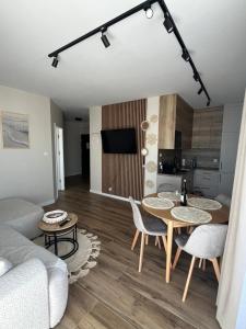 a living room with a couch and a table at Gąski Flow w Nadmorskie apartamenty in Gąski +16 photos