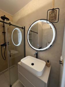 a bathroom with a sink and a mirror at Gąski Flow w Nadmorskie apartamenty in Gąski