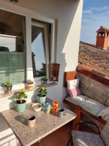 a balcony with a table with potted plants on it at Apartman Karo in Vrsar