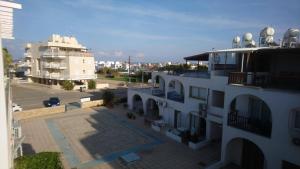 an aerial view of a white building with a parking lot at Apartment Sun Kapparis in Paralimni