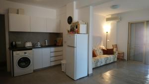 a kitchen with a refrigerator and a couch in a room at Apartment Sun Kapparis in Paralimni +6 photos