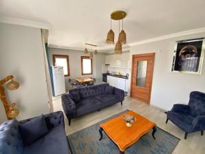 a living room with blue couches and a table at Sea View Fethiye in Fethiye