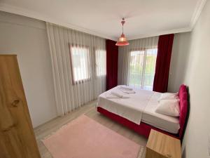a bedroom with a bed and a window with red curtains at Sea View Fethiye in Fethiye