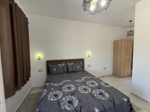 a bedroom with a bed with a black comforter at Bujtina4A Rrenc in Renc