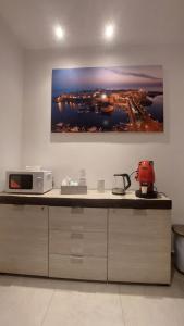 a kitchen with a microwave and a painting on the wall at La Pilozza in Gallipoli +34 photos
