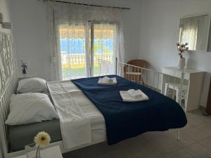 a bedroom with a bed with two towels on it at Syvota Sunset Apartments in Perdika