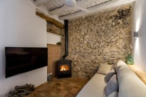 a room with a stone wall with a couch and a fireplace at Casa Rural Boutique - Ca Bolo in Pinell de Bray