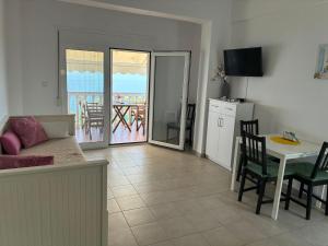 a living room with a couch and a table and a kitchen at Syvota Sunset Apartments in Perdika