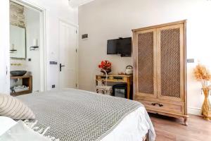 a bedroom with a bed and a desk and a television at Mediha Hanım Konağı Alaçatı in Çeşme