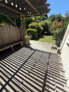 a patio with a bench under a wooden pergola at Pretty little house Jolie petite maison in Rueil-Malmaison +1 photo