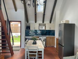 una cucina con tavolo e frigorifero in acciaio inox di Little Breede Cottage a Witsand Altre 22 foto