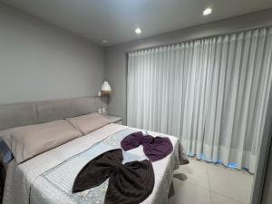 una camera da letto con un letto con due asciugamani sopra di Apartamento com Piscina no Centro e a poucos metros do mar de Torres -RS a Torres Altre 12 foto