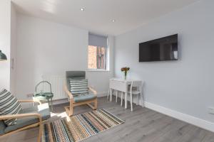 a living room with a tv and a chair and a table at Lytham St Annes Luxury Apartment - No 1 Tides Reach in Lytham St Annes +8 photos