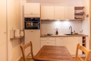 una pequeña cocina con mesa de madera y sillas en La p'tite barque des remparts Mer, en Saint-Malo 13 fotos más