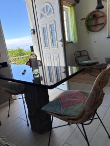a glass table with a bottle of wine and chairs at Lucky Lemons Boutique Houses Madeira 1 in Calheta