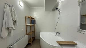 a white bathroom with a tub and a sink at Apartament spațios, 2 dormitoare, confortabil in Chişinău +10 photos