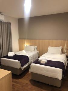 a hotel room with two beds in a room at Legacy Hotel Guaratinguetá - Ao lado de Aparecida -SP in Guaratinguetá