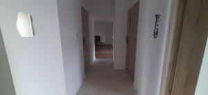 a hallway with white walls and a hallway with doors at Apartamenty Kraków-Bielany in Kraków +2 photos