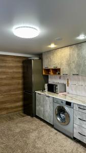 a kitchen with a washing machine and a refrigerator at Частный благоустроенный дом in Borovoye