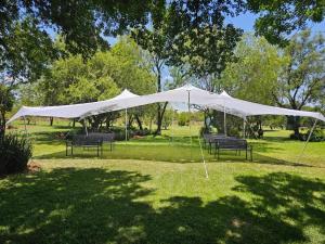 a group of benches under a white tent in a park at Antelope Farm Events in Pretoria