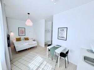 a white living room with a table and a couch at Endla Hostel ja Apartamendid in Haapsalu