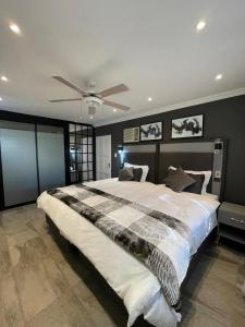 a bedroom with a large bed with a ceiling fan at Antelope Farm Events in Pretoria