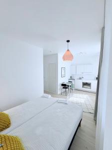 a white room with a bed and a kitchen at Endla Hostel ja Apartamendid in Haapsalu