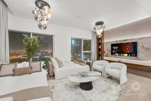 a living room with white furniture and a fireplace at Luxury Apartments - Urban Oasis by Missoni - Business Bay - Canal View - 10 Minutes from Dubai Mall Burj Khalifa in Dubai