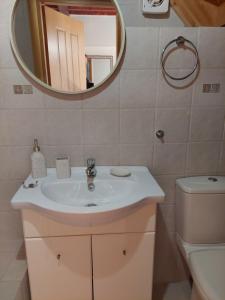 Un baño con lavabo, espejo e inodoro. en Casa Cretese Chania, en Tsikalariá 20 fotos más
