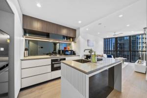 ブリスベンにあるQueen's Residence - Brand New Apt on the Star BNEの白いキャビネットとカウンタートップを備えたキッチン +18枚の写真